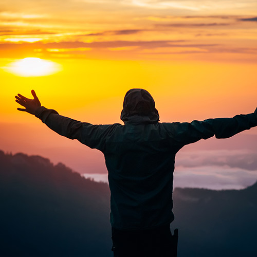 stock-photo-man-traveler-hands-raised-silhouette-outdoor-with-sunset-sky-mountains-on-background-